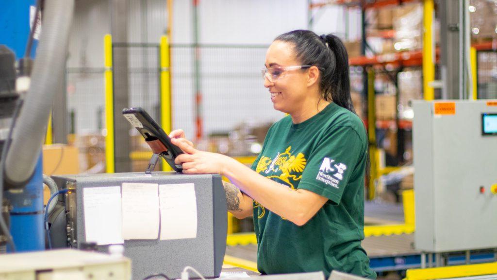 NewStream employee reviewing a tablet