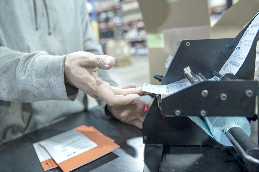 NewStream employee placing packaging label